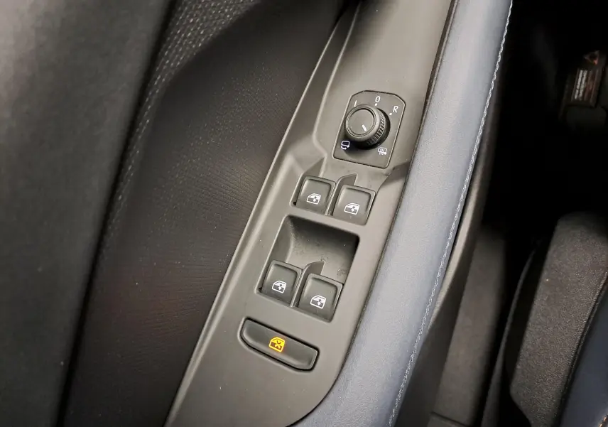 Gros plan sur les commandes des vitres et rétroviseurs côté conducteur du CUPRA TERRAMAR 2025 avec garniture intérieure bleu Cosmos.