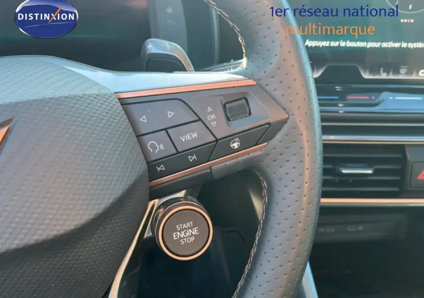 Gros plan sur le volant perforé et le bouton start/stop du CUPRA Formentor gris magnétique, avec commandes intégrées.