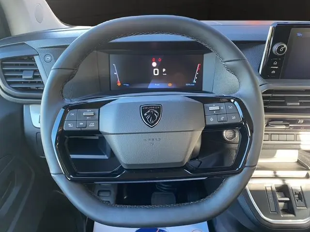 Vue rapprochée du volant noir du Peugeot Expert XL 2025 avec combiné numérique et tableau de bord gris acier.