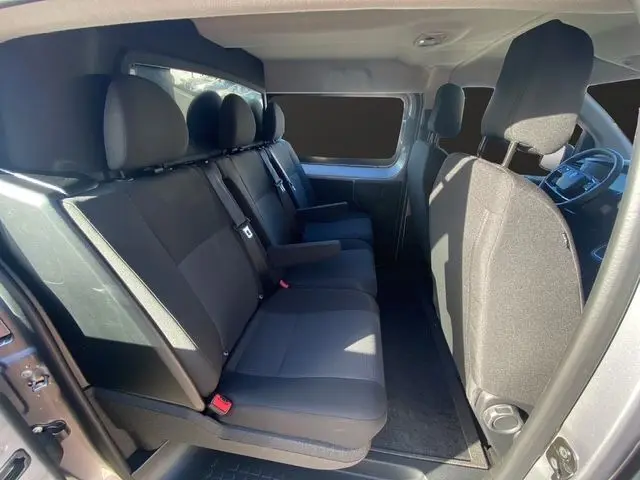 Vue intérieure côté droit du Peugeot Expert Cabine Approfondie gris acier, montrant les sièges arrière et avant en tissu noir.