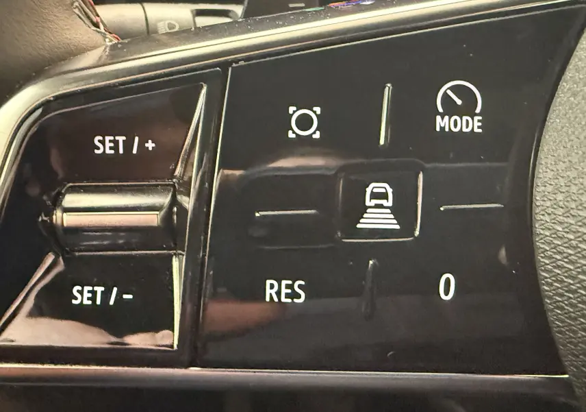 Gros plan sur les commandes au volant noir du Renault Espace VI E-Tech 200 Esprit Alpine, boutons de régulateur et mode.