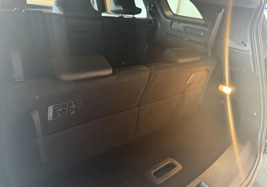 Vue intérieure du coffre du Renault Espace VI E-Tech 200 Esprit Alpine noir, montrant la banquette arrière rabattue.