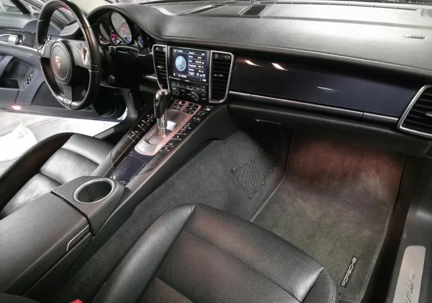 Intérieur noir cuir de Porsche Panamera 2011 vu côté passager avec console centrale et tableau de bord.