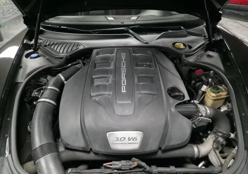 Moteur 3.0 V6 Porsche Panamera diesel vu de dessus sous le capot ouvert, avec cache moteur noir.