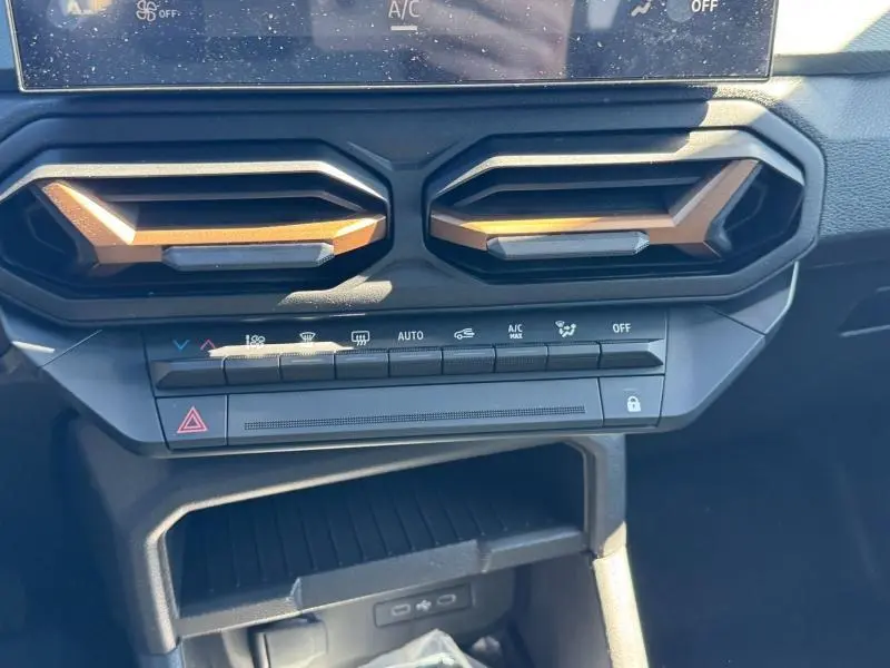 Détail du tableau de bord noir du Dacia Duster 2025 avec aérateurs hexagonaux et commandes climatisation.