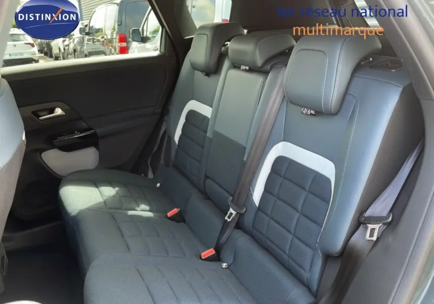 Vue intérieure de la banquette arrière du Citroën C5 Aircross Hybrid, avec sellerie tissu et cuir noir aux surpiqûres blanches.