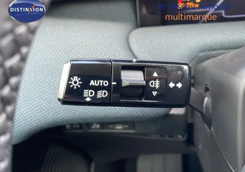 Gros plan sur la commande des phares et clignotants du Citroën C5 Aircross Hybrid, intérieur tissu gris.