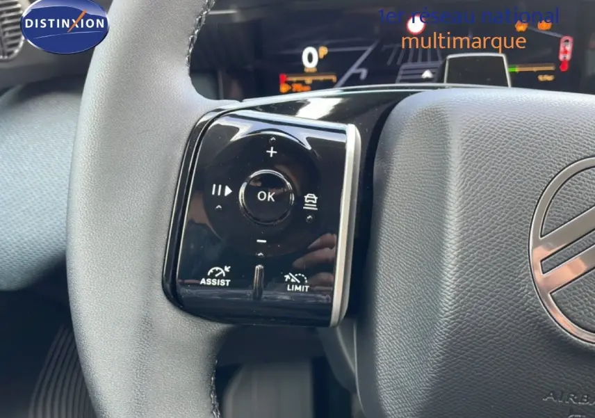 Gros plan sur le volant du Citroën C5 Aircross Hybrid vert Astoria, avec commandes intégrées et tableau de bord numérique en arrière-plan.