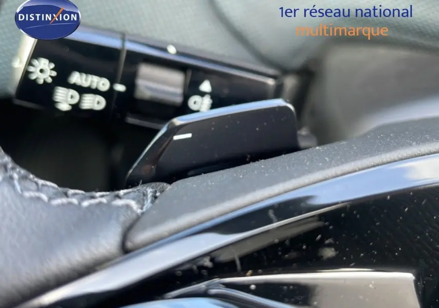 Gros plan sur la palette de changement de vitesse côté droit du volant cuir noir d'une Citroën C5 Aircross Hybrid vert Astoria.