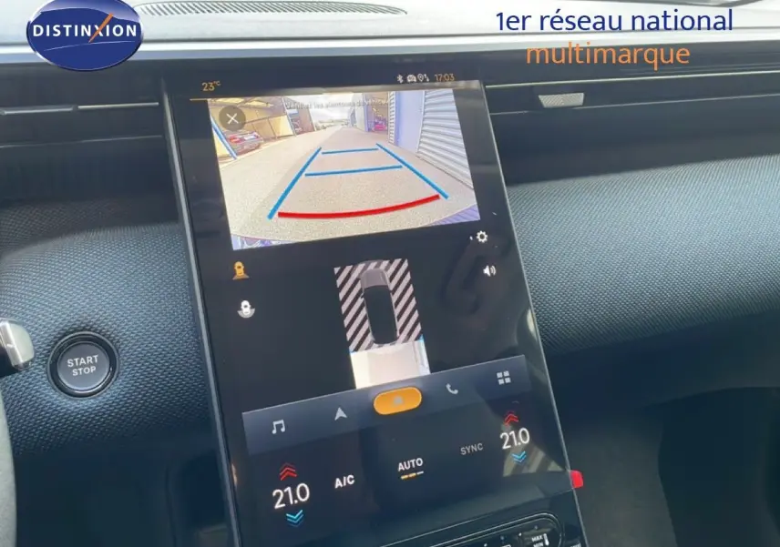 Vue rapprochée de l’écran tactile central du Citroën C5 Aircross Hybrid vert Astoria, affichant la caméra de recul et la climatisation.