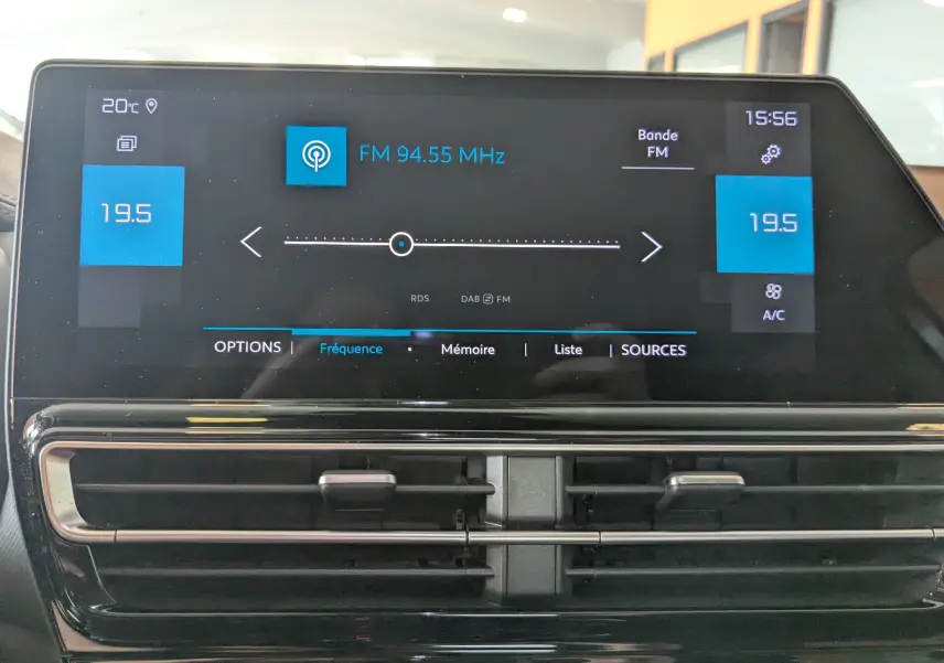 Écran tactile central du tableau de bord du Citroën C5 Aircross gris Artens, affichant la radio FM et la climatisation à 19,5°C.