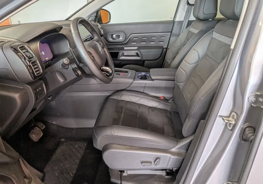 Vue intérieure côté conducteur du Citroën C5 Aircross gris Artens, sièges cuir et alcantara noirs avec tableau de bord moderne.