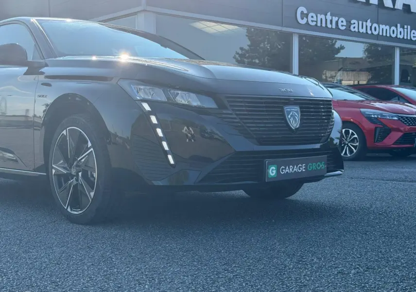 Peugeot e-308 noir Perla Nera vue 3/4 avant avec calandre noire et feux LED verticaux allumés.
