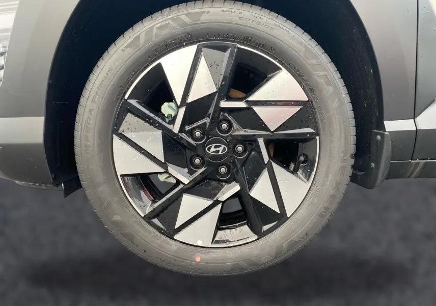 Gros plan sur la roue avant droite gris foncé du Hyundai Kona 2025 avec jante alliage noire et argentée au design géométrique.