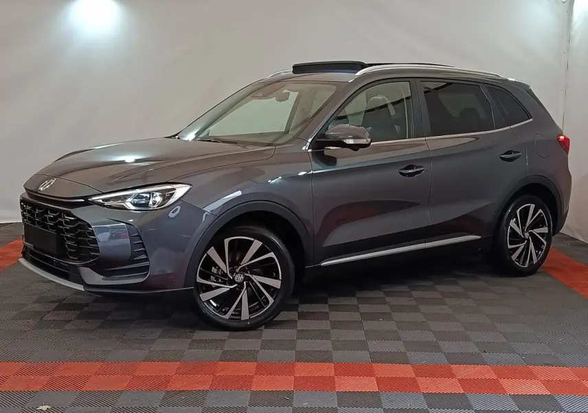 MG Motor ZS gris foncé en vue 3/4 avant droit, avec jantes alliage noires et toit ouvrant panoramique.