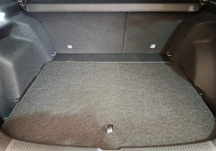 Coffre spacieux et vide du MG Motor ZS 1.5L Hybrid+ Luxury gris foncé, vue intérieure depuis l'arrière ouverte.