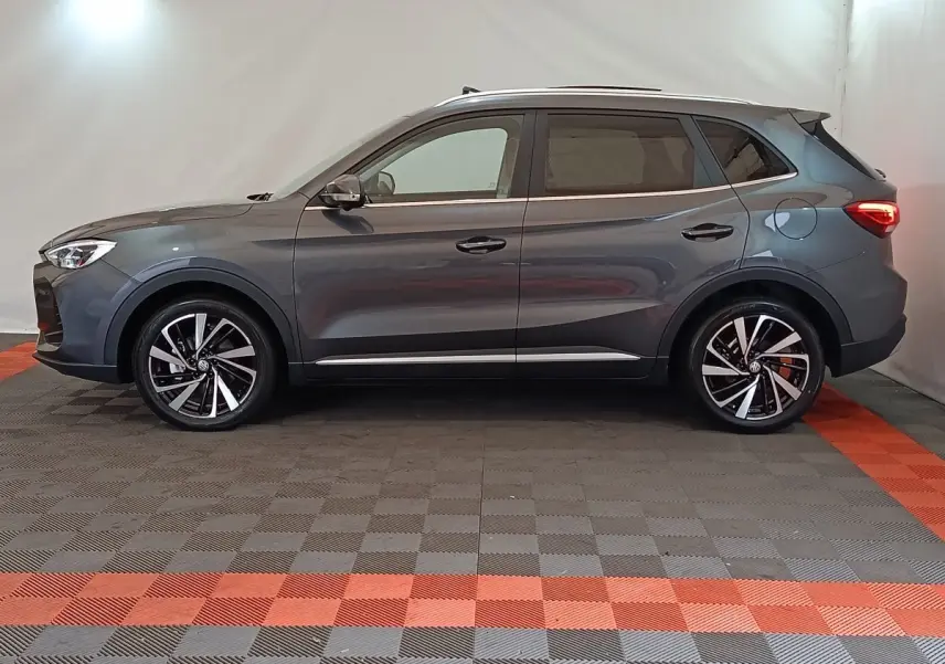Profil droit du MG ZS gris foncé 2026 avec jantes alliage noires et toit ouvrant panoramique visible.