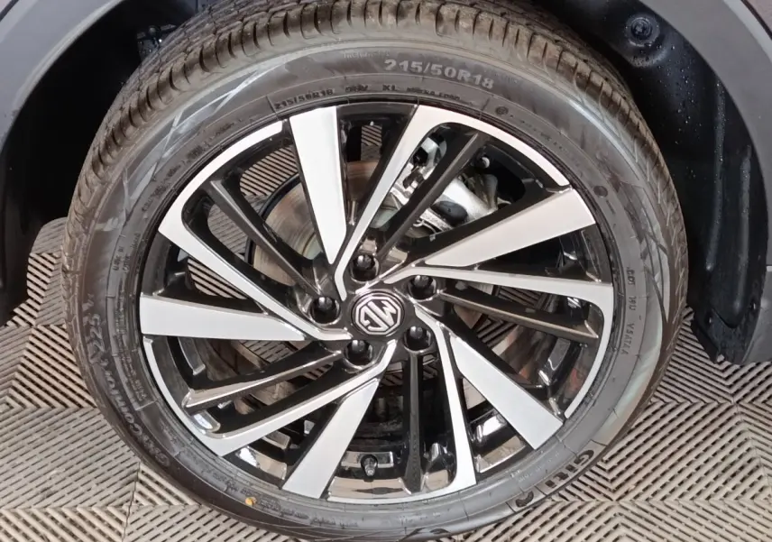 Gros plan sur la jante alliage bicolore noir et argent du MG ZS gris foncé, roue avant droite visible.