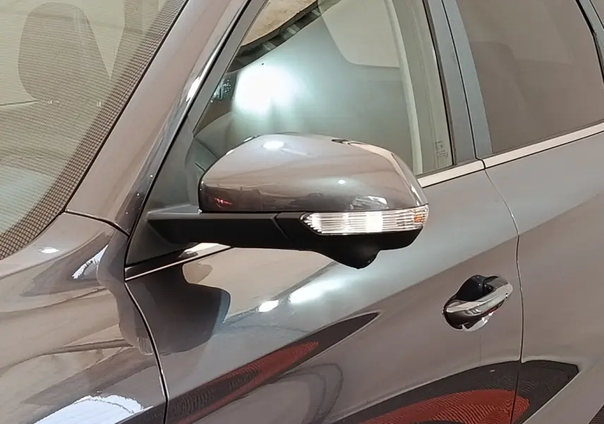 Gros plan sur le rétroviseur côté gauche gris foncé du MG Motor ZS 1.5L Hybrid+ Luxury 2026 avec poignée de porte visible.