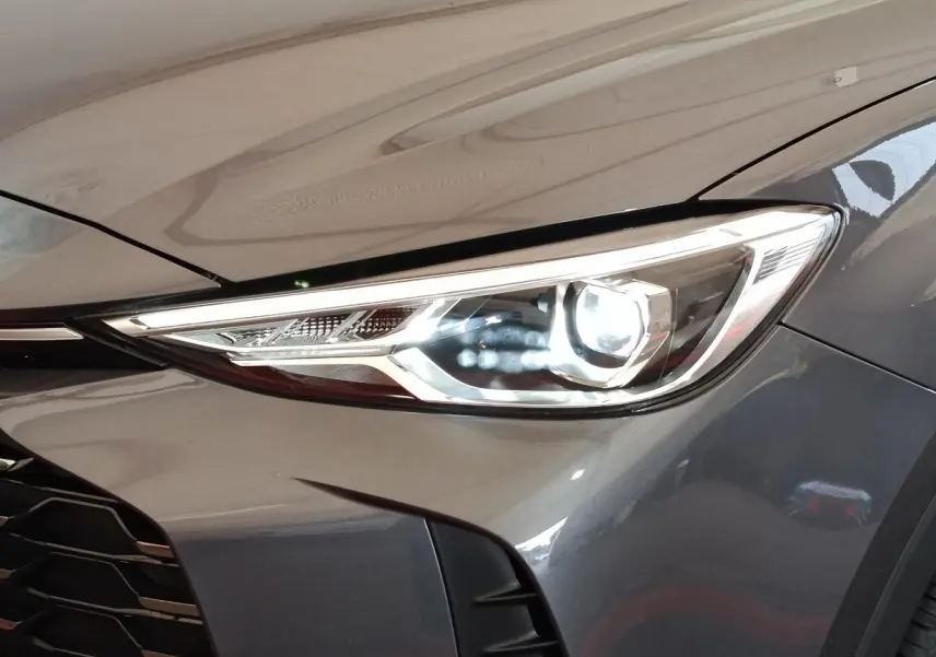 Gros plan sur le phare avant droit du MG MOTOR ZS gris foncé, mettant en valeur son design LED moderne.