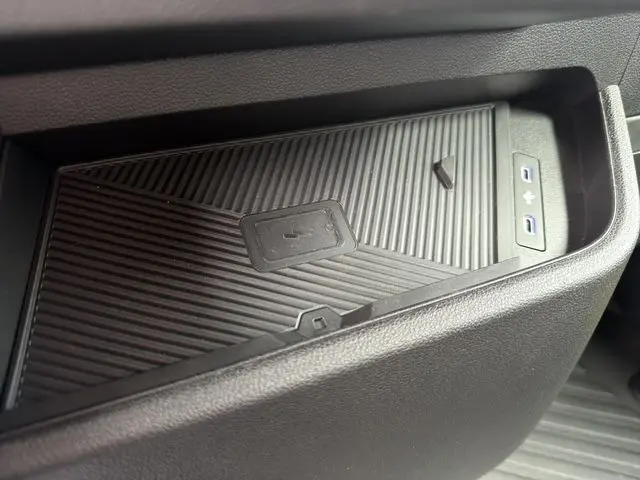 Détail du chargeur smartphone à induction intégré dans la console intérieure du Renault Master blanc 2025.