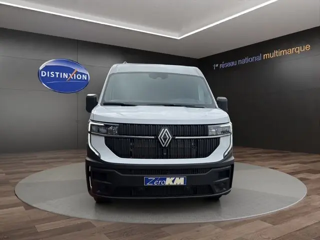 Vue de face du Renault Master blanc 2025 avec calandre noire et logo central dans un showroom.