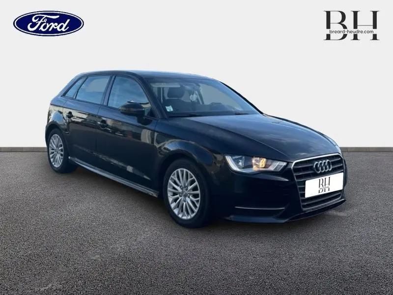 Audi A3 Sportback noir brillant vue 3/4 avant droit avec phares allumés sur fond neutre