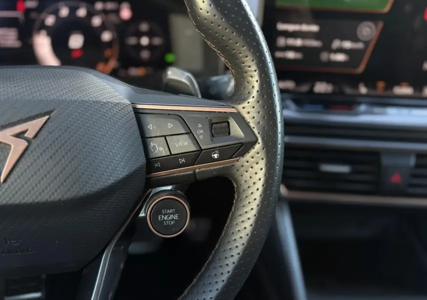 Gros plan sur le volant cuir perforé noir avec logo CUPRA cuivré et commandes intégrées du Formentor 2025.