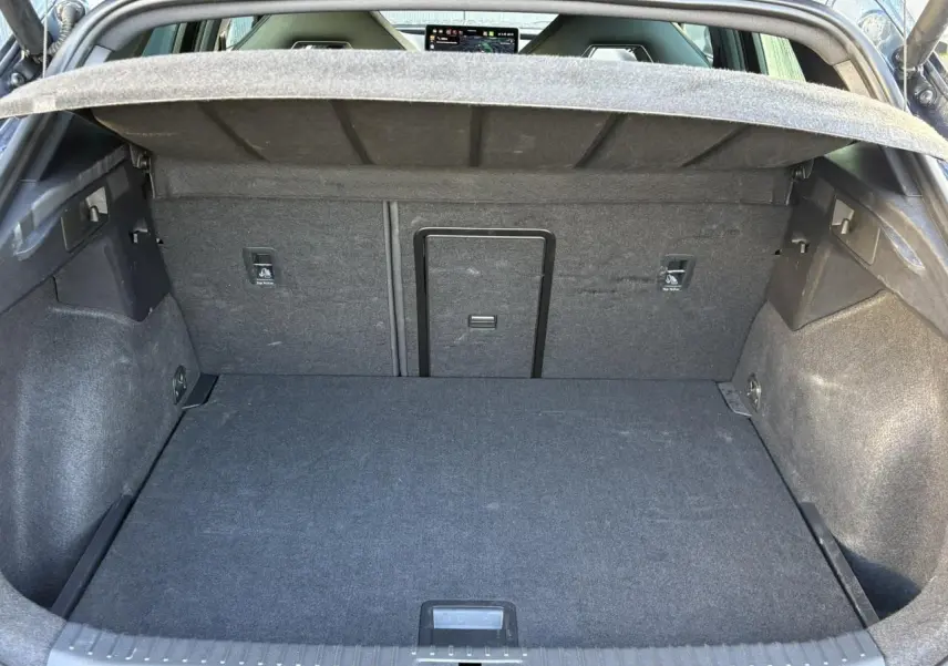 Coffre ouvert vu de l'arrière du CUPRA Formentor gris Magnétique, montrant l'espace de chargement et la trappe à skis.