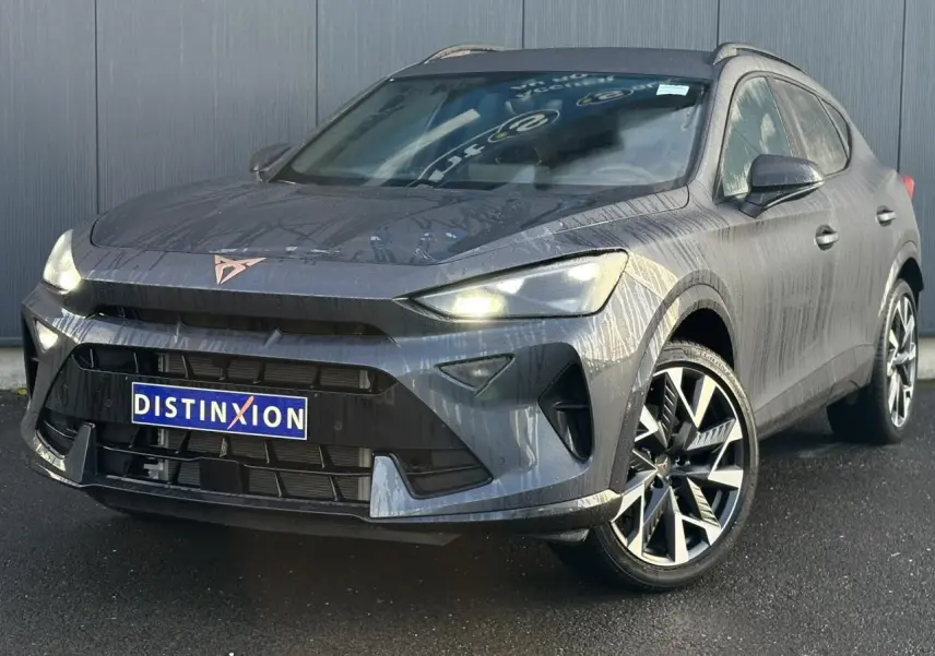 Vue 3/4 avant droite d'une CUPRA Formentor blanche avec jantes alliage noires et calandre marquée.