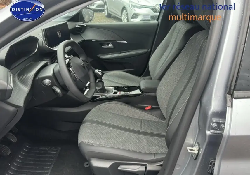 Vue intérieure côté conducteur de la Peugeot 208 1.2 PureTech 100 Allure gris Artense avec sièges tissu gris et console centrale noire.