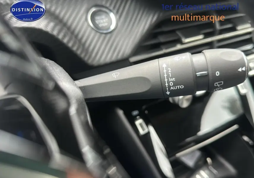 Gros plan sur la commande d’essuie-glace côté gauche du tableau de bord d’une Peugeot 208 gris Artense 2024.