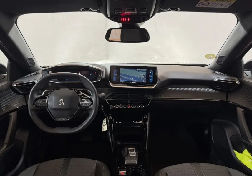 Vue intérieure avant du Peugeot 2008 gris clair 2023, tableau de bord avec écran tactile central et volant multifonctions cuir.