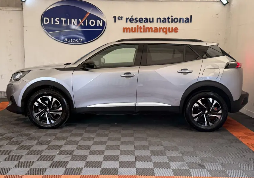 Peugeot 2008 gris clair vue de profil côté gauche, avec jantes noires et toit noir contrastant.