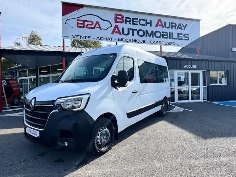 Renault Master Combi blanc minéral vu en 3/4 avant droit devant un garage Brech Auray Automobiles.