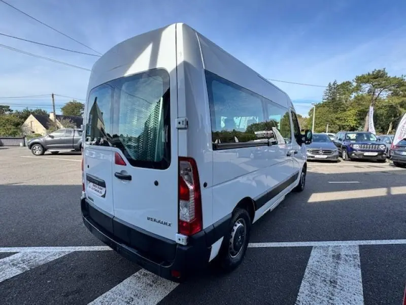 Vue 3/4 arrière droite du Renault Master Combi blanc minéral, avec fenêtres latérales et porte coulissante visible.