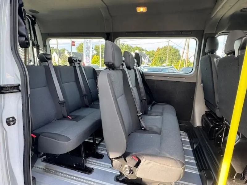 Vue intérieure latérale droite du Renault Master Combi blanc minéral, montrant les sièges en tissu gris pour 9 places TPMR.