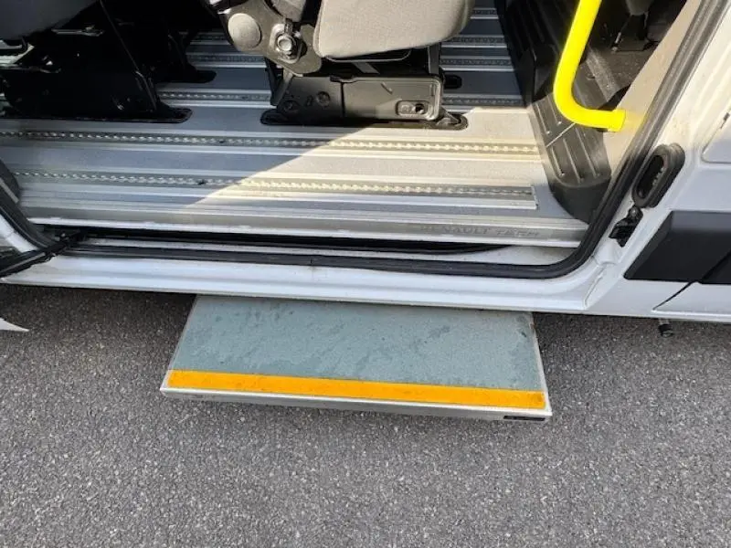 Vue rapprochée de la porte latérale ouverte du Renault Master Combi blanc avec marche-pied déployé et siège passager visible.