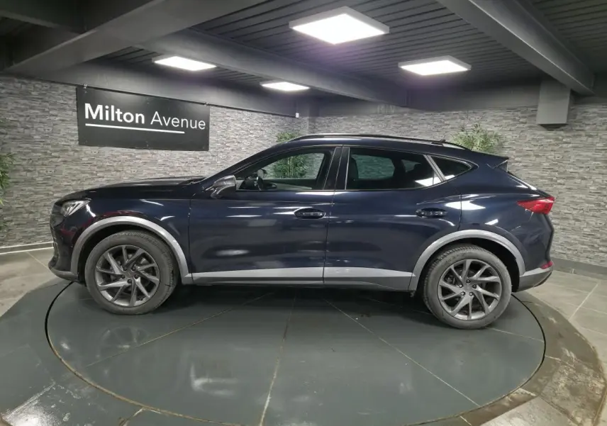 Vue latérale droite d'un CUPRA Formentor bleu avec jantes alliage 18 pouces et protections de bas de caisse grises.