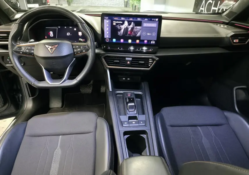 Vue intérieure avant du CUPRA Formentor 2022 avec tableau de bord noir, volant sport multifonction et écran tactile central.