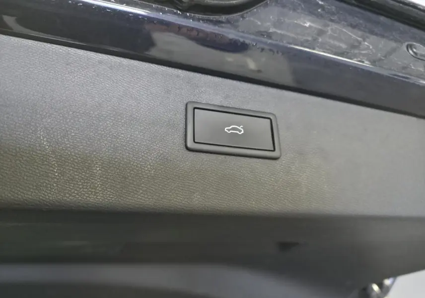 Bouton d'ouverture électrique du hayon sur la face intérieure du coffre d'une CUPRA Formentor bleu.
