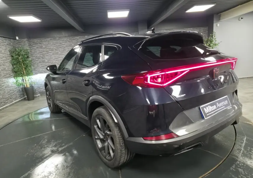 Vue 3/4 arrière droite d'un CUPRA Formentor bleu avec feux arrière LED en bandeau lumineux et jantes alliage 18 pouces.