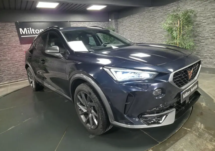 Vue 3/4 avant droit du CUPRA Formentor bleu avec calandre distinctive et jantes alliage 18 pouces en intérieur showroom.
