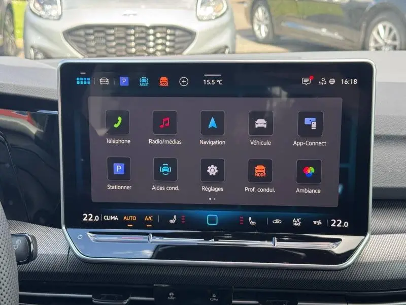 Écran tactile central de la Volkswagen Golf 1.5 eTSI R-Line 2026, affichant le menu multimédia et climatisation.