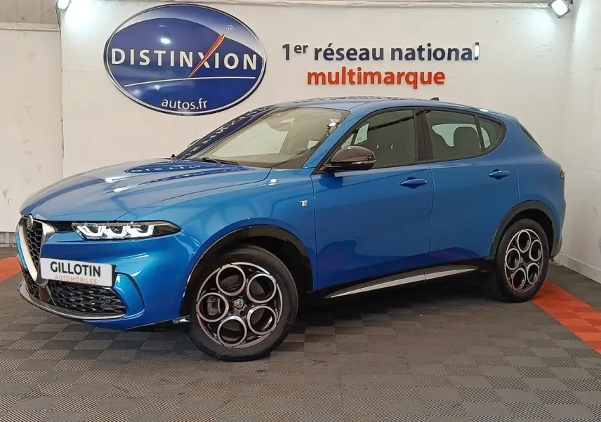 Vue 3/4 avant gauche d'une Alfa Romeo Tonale 1.5T Hybrid 160 VGT bleu avec jantes distinctives à cercles entrelacés.