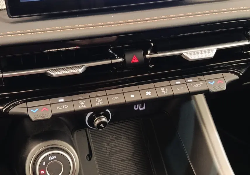 Vue rapprochée du tableau de bord central de l'Alfa Romeo Tonale 2023, montrant les commandes de climatisation et la roulette de sélection.