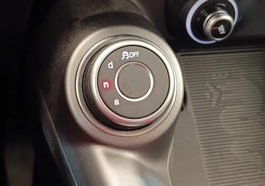 Gros plan sur la molette de sélection de mode de conduite de l'Alfa Romeo Tonale 1.5T Hybrid, intérieur noir.