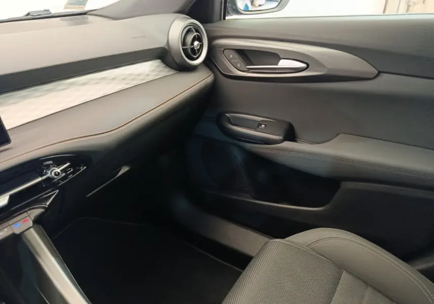 Vue intérieure côté passager de l'Alfa Romeo Tonale 1.5T Hybrid 160 VGT avec tableau de bord noir et surpiqûres marron.