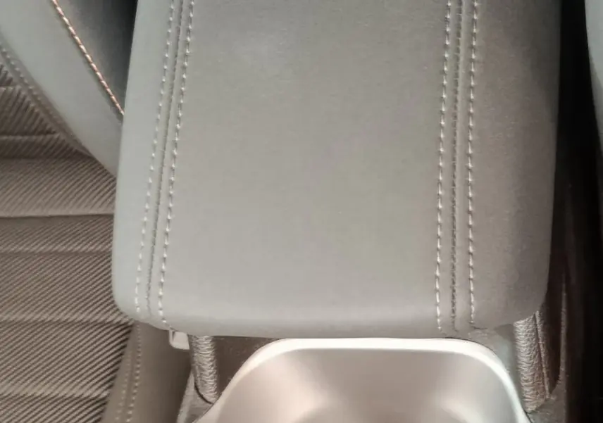 Gros plan sur l'accoudoir central gris et porte-gobelet de l'intérieur d'une Alfa Romeo Tonale 2023.