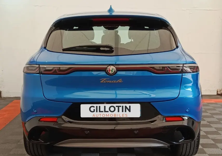 Vue arrière de l'Alfa Romeo Tonale bleu 2023 avec feux LED reliés et double sortie d'échappement noire.